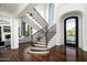 Elegant entryway with curved staircase and black iron railings at 9848 E Parkside Ln, Scottsdale, AZ 85255