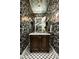 Powder room features dark wood vanity, marble countertop and leaf wallpaper at 9848 E Parkside Ln, Scottsdale, AZ 85255