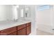 Modern bathroom with brown vanity and quartz countertop at 8628 W Solano Dr, Glendale, AZ 85305