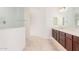 Bathroom with double vanity, large mirror, and walk-in shower at 8628 W Solano Dr, Glendale, AZ 85305