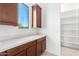 Laundry room with white cabinets, quartz countertops, and a window at 8628 W Solano Dr, Glendale, AZ 85305