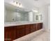 Elegant bathroom with dual vanities, a large mirror, and updated lighting at 8628 W Solano Dr, Glendale, AZ 85305