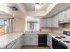 Open kitchen with grey cabinets, granite counters and stainless steel appliances at 526 E Viola St, Casa Grande, AZ 85122