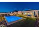 Night view of a rectangular pool and grassy backyard, illuminated at 24282 S 219Th St, Queen Creek, AZ 85142