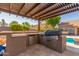 Outdoor kitchen with built-in grill and refrigerator at 10913 N 153Rd Ln, Surprise, AZ 85379