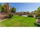 Spacious backyard with grassy area, mature trees, and a pergola at 10913 N 153Rd Ln, Surprise, AZ 85379