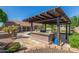 Outdoor kitchen, pool, pergola, and lush landscaping create a relaxing backyard oasis at 10913 N 153Rd Ln, Surprise, AZ 85379