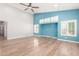 Living room with vaulted ceiling, wood floors and blue accent wall at 10913 N 153Rd Ln, Surprise, AZ 85379