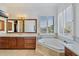 Elegant bathroom with a large soaking tub, double vanity, and plantation shutters at 10793 E La Junta Rd, Scottsdale, AZ 85255