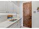 Bright laundry room with white cabinets and a utility sink at 10793 E La Junta Rd, Scottsdale, AZ 85255