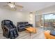 Living room features a massaging chair, balcony access, and tile floors at 12212 N Paradise Village S Pkwy # 451, Phoenix, AZ 85032