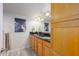 Bathroom with double sinks, wood cabinets, and a beach-themed picture at 12212 N Paradise Village S Pkwy # 451, Phoenix, AZ 85032