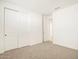 Spacious bedroom with neutral carpet, double door closet, and an additional door at 37517 W San Clemente St, Maricopa, AZ 85138