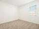 Bright bedroom with neutral carpet and large window at 37517 W San Clemente St, Maricopa, AZ 85138