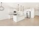 Modern kitchen with white cabinets, island, and stainless steel appliances at 37517 W San Clemente St, Maricopa, AZ 85138