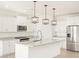 Modern kitchen with white cabinets, island, and stainless steel appliances at 37517 W San Clemente St, Maricopa, AZ 85138