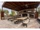 Covered outdoor kitchen and dining area with built-in grill and seating at 21423 S 147Th St, Gilbert, AZ 85298