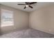 Simple bedroom with gray carpet, ceiling fan and window blinds at 6034 E Hillview St, Mesa, AZ 85205