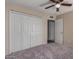 Bedroom with gray carpet, ceiling fan and double door closet at 6034 E Hillview St, Mesa, AZ 85205
