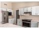 Updated kitchen with stainless steel appliances and white cabinetry at 6034 E Hillview St, Mesa, AZ 85205