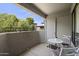 Private balcony with small table and chairs, offering a view of trees and other buildings at 2025 E Campbell Ave # 260, Phoenix, AZ 85016