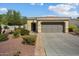 Tan two-car garage home with a manicured front yard at 22303 N Montecito Ave, Sun City West, AZ 85375