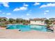 Community pool with a large deck and surrounding homes at 15112 W Hadley St, Goodyear, AZ 85338