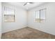 Bright bedroom with two windows, ceiling fan, and neutral carpeting at 15112 W Hadley St, Goodyear, AZ 85338
