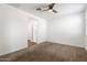 Bedroom with ceiling fan, neutral carpet, and access to bathroom at 15112 W Hadley St, Goodyear, AZ 85338