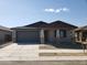 One story home with gray garage door and stone accents at 20542 N 226Th Ln, Surprise, AZ 85387