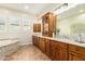 Bathroom with double vanity, granite countertop, and a soaking tub at 5088 S Ponderosa Dr, Gilbert, AZ 85298