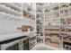 Large pantry with ample shelving for food storage and wine rack at 11818 W Luxton Ln, Avondale, AZ 85323