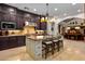 Island kitchen with granite countertops and dark wood cabinetry at 36975 N Mirabel Club Dr, Scottsdale, AZ 85262