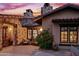 Exterior view of the home at sunset, showcasing stonework at 36975 N Mirabel Club Dr, Scottsdale, AZ 85262