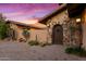 Arched wood entry door with stone accents at 36975 N Mirabel Club Dr, Scottsdale, AZ 85262