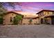 Elegant home exterior at sunset with stone and stucco at 36975 N Mirabel Club Dr, Scottsdale, AZ 85262