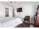 Bedroom with a queen-size bed, TV, and a cozy armchair at 23008 E Galveston St, Mesa, AZ 85212