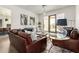Open living room with leather couches and a view into the kitchen at 23008 E Galveston St, Mesa, AZ 85212