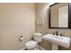 Elegant powder room with pedestal sink, toilet and framed mirror at 578 E Laddoos Ave, San Tan Valley, AZ 85140