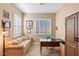 Bright home office features a comfortable sofa, large desk, and built-in shelving at 578 E Laddoos Ave, San Tan Valley, AZ 85140
