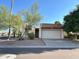 Tan colored stucco home with a white garage door and mature landscaping at 7006 E Jensen St # 83, Mesa, AZ 85207