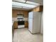 Kitchen boasts wood cabinets, tile floors, and a white refrigerator at 7006 E Jensen St # 83, Mesa, AZ 85207