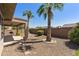 Desert landscape with covered patio, palm trees, and gravel at 19051 N Aztec Point Dr, Surprise, AZ 85387