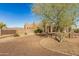 View of a beautiful Southwestern style home with mature trees and a gravel driveway at 31527 N 174Th St, Rio Verde, AZ 85263