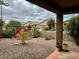 Spacious backyard with gravel landscaping, featuring a patio and a swing set at 148 S 225Th Ln, Buckeye, AZ 85326