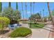 Relaxing community patio area with seating and lush landscaping at 17404 N 99Th Ave # 108, Sun City, AZ 85373