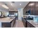 Spacious kitchen featuring granite island, stainless steel appliances, and dark wood cabinets at 29405 N 123Rd Gln, Peoria, AZ 85383