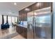 Kitchen with stainless steel refrigerator, granite countertops, and dark wood cabinets at 29405 N 123Rd Gln, Peoria, AZ 85383
