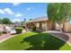 Landscaped backyard with artificial turf and a large covered patio at 8894 E Sheena Dr, Scottsdale, AZ 85260