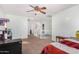 Bedroom with ceiling fan, carpet, and a view of upper hallway and bathroom at 18611 W Sunnyslope Ln, Waddell, AZ 85355